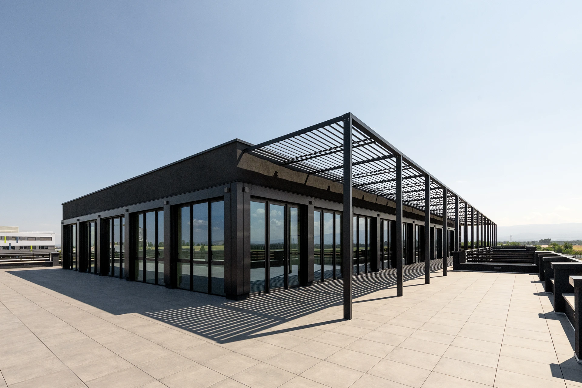 Le nouveau siège social d’un leader français de la maison individuelle affirme les valeurs de la marque à travers une architecture monolithique, moderne et pérenne. Les espaces, organisés autour d’un noyau technique central, offrent souplesse et évolutivité, tandis que les ambiances intérieures et la grande terrasse panoramique renforcent la qualité d’usage.