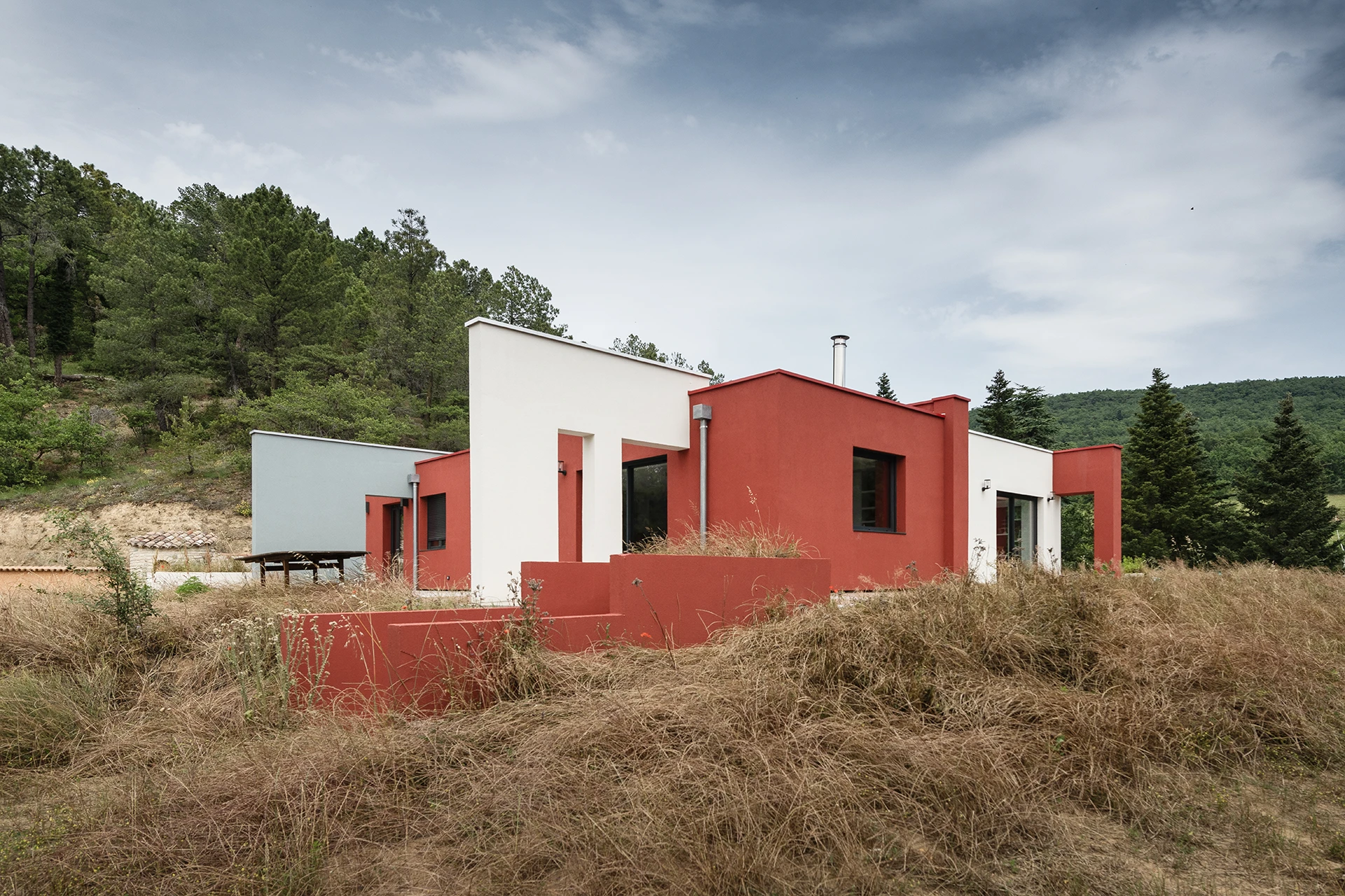 La réhabilitation complète de ce pavillon des années 1960, situé dans un site remarquable de la Drôme, redonne vie à la maison par une restructuration contemporaine et écoresponsable. Organisée autour d’une cuisine-patio ouverte sur la nature, elle allie fonctionnalité, couleurs vibrantes et qualité environnementale.