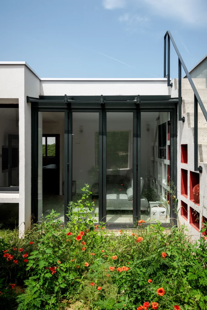 La réhabilitation complète de ce pavillon des années 1960, situé dans un site remarquable de la Drôme, redonne vie à la maison par une restructuration contemporaine et écoresponsable. Organisée autour d’une cuisine-patio ouverte sur la nature, elle allie fonctionnalité, couleurs vibrantes et qualité environnementale.