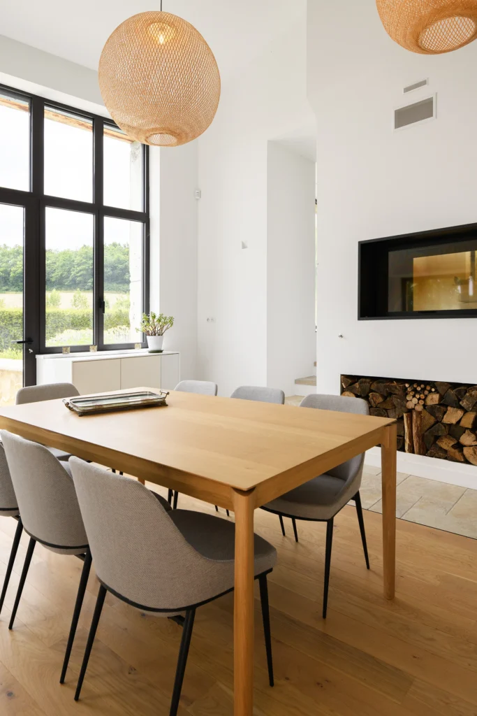 Rénovation complète d’une maison de famille – Drôme
Nichée au cœur des paysages de la Drôme, cette maison a fait l’objet d’une rénovation intégrale. Le projet a consisté à redonner vie à une bâtisse aux volumes autrefois fermés et cloisonnés, pour en révéler tout le potentiel architectural et spatial.
L’intervention a porté sur l’ensemble de l’enveloppe : les façades ont été restaurées, les ouvertures repensées et créées pour offrir de nouveaux cadrages sur le paysage, mettant en valeur la pierre existante et la richesse du contexte environnant.
À l’intérieur, les espaces ont été entièrement réorganisés. Le plan initial, fragmenté et contraint, a laissé place à des enchaînements fluides, où les pièces dialoguent entre elles et s’ouvrent généreusement sur l’extérieur. Chaque ouverture devient un tableau vivant, cadrant une portion de nature : champs de blé, forêt, lumière changeante.
Le cœur de la maison se structure autour de volumes entremêlés. Une cheminée centrale, élément à la fois architectural et domestique, relie les grands volumes de la cuisine en double hauteur et le salon, plus intime et chaleureux. Dans une autre aile, à l’étage, une seconde cuisine a été aménagée. Elle prolonge l’esprit du projet : fonctionnalité discrète, ouverture maîtrisée, cadrages sensibles sur le paysage.
Les ambiances varient selon les espaces : une chambre se déploie autour d’un vide intérieur, jouant avec les hauteurs et les couleurs ; le salon TV, équipé d’une bibliothèque et de rangements intégrés, offre un lieu de retrait, propice au calme tout en restant connecté à l’extérieur.
Le choix des matériaux renforce l’identité sobre et chaleureuse du lieu : pierre naturelle, travertin, parquet en chêne et surfaces en solid surface s’équilibrent pour créer une atmosphère douce, intemporelle et raffinée.
Les ouvertures ont été dessinées pour favoriser la lumière naturelle et créer des liens visuels avec le paysage, tout en accompagnant les usages quotidiens. À l’extérieur, une piscine s’insère discrètement dans le jardin paysager, entourée de terrasses orientées pour profiter du soleil tout au long de la journée. La maison se fond progressivement dans son environnement, entre les cultures et les bois, dans un dialogue apaisé avec le site.
Enfin, les espaces de nuit, regroupés dans une aile plus en retrait, assurent calme et sérénité. Ils sont complétés par une salle de sport et un second salon dédié aux plus jeunes, pour que chacun puisse vivre la maison à son rythme, en toute liberté.