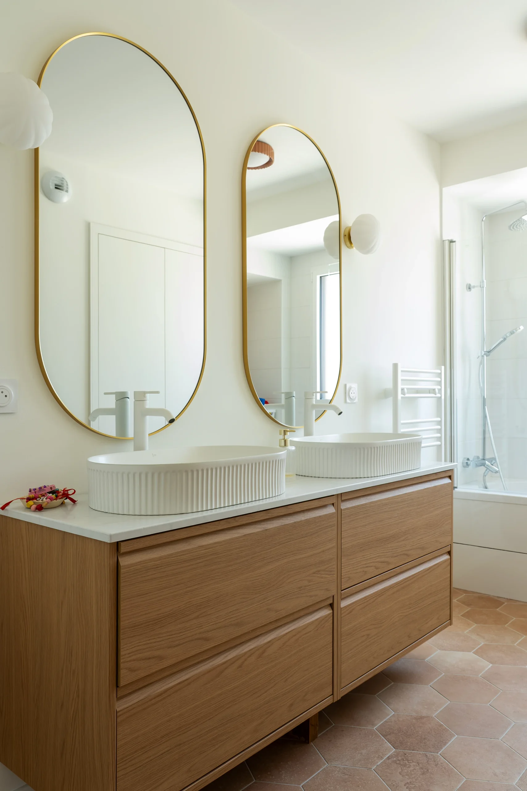 Salle de bains d’un logement du Domaine Marquise avec meuble vasque en bois