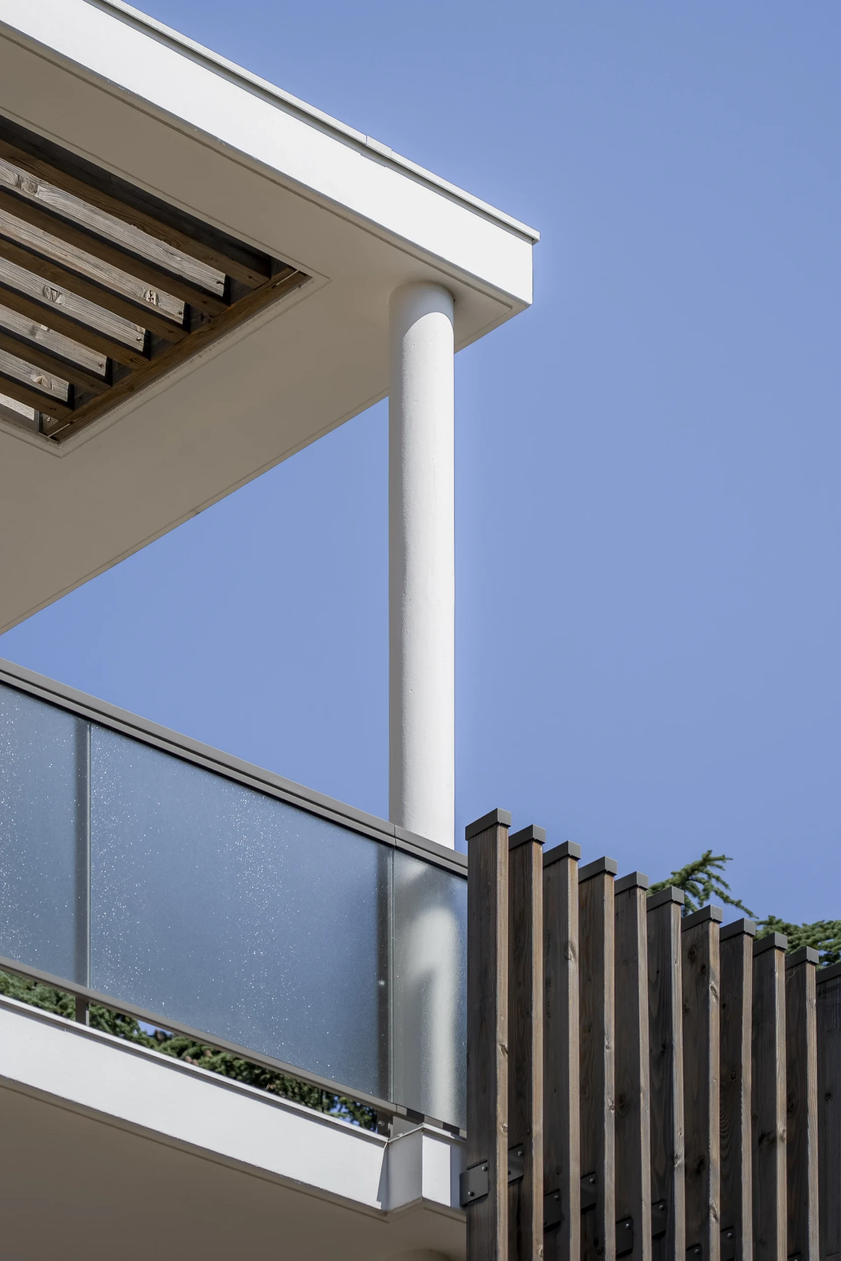 Détail d’un balcon avec garde-corps vitré et claustra en bois au Domaine Marquise