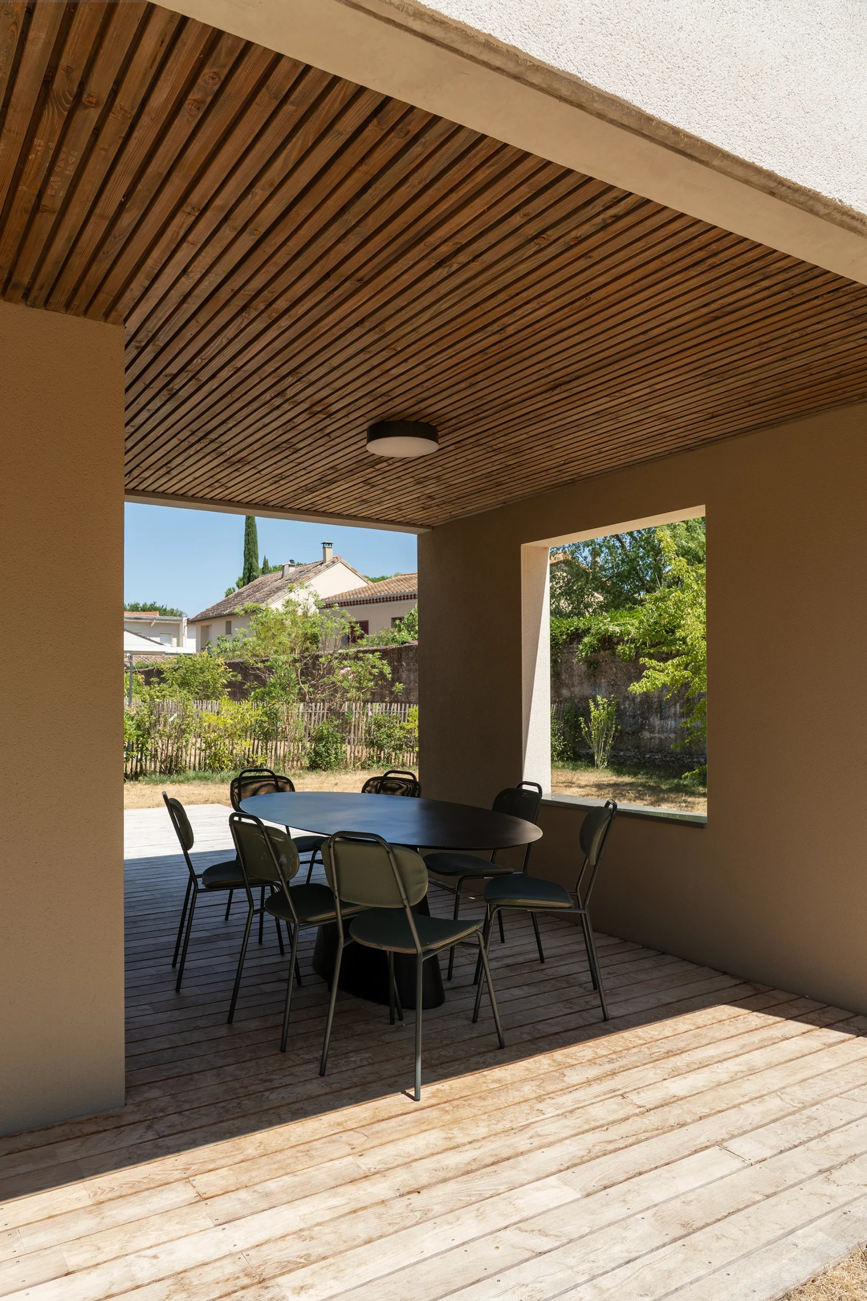 Terrasse couverte en bois d’un logement du Domaine Marquise ouverte sur le jardin
