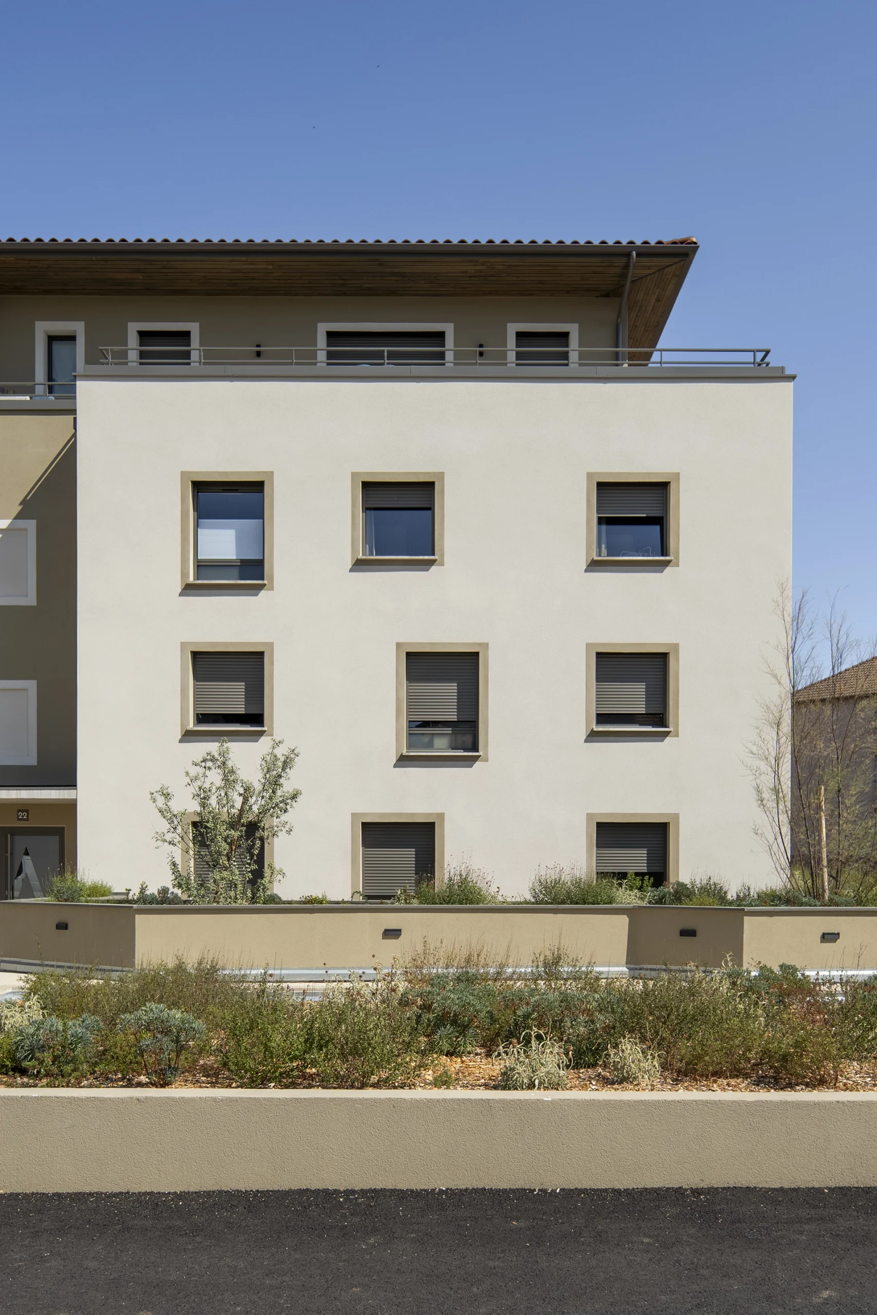 Façade de logements du Domaine Marquise bordée de jardins plantés