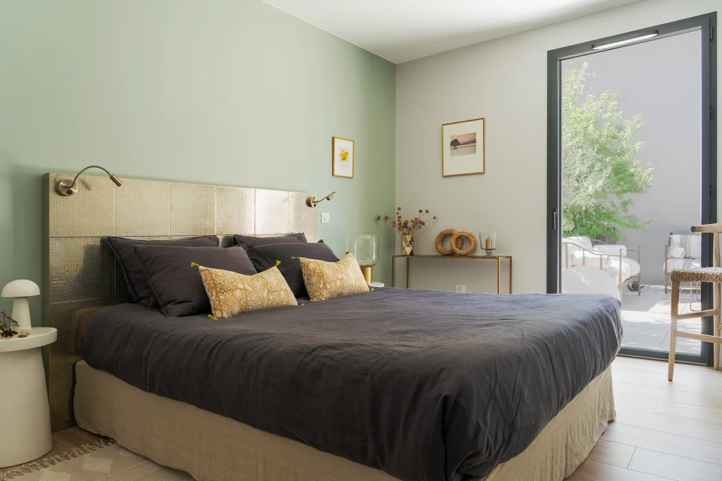 Une ambiance intérieure douce et lumineuse où la baie vitrée crée une continuité directe entre la chambre et son espace extérieur.