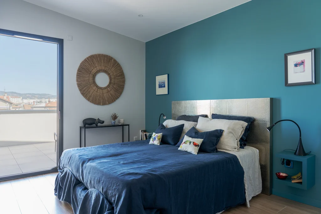La chambre bénéficie d’une large ouverture sur l’extérieur, prolongeant visuellement l’espace et apportant une lumière naturelle généreuse.