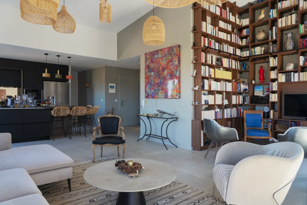 La grande pièce de vie associe cuisine, salon et bibliothèque dans une composition intérieure ouverte, lumineuse et conviviale.